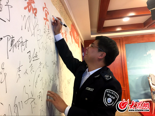 4、临沂市环境保护局兰山分局副局长余广彬在签名墙上签名.png