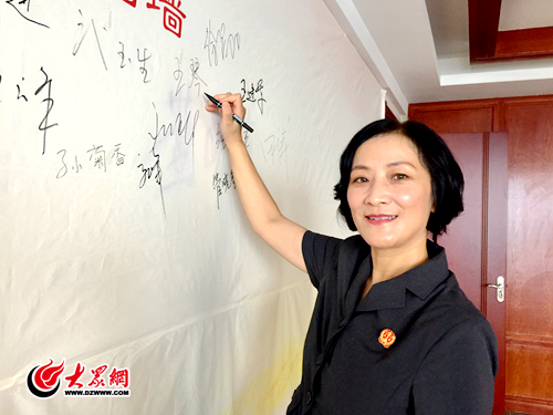 法官王琴在大众网嘉宾签名墙上签名.png