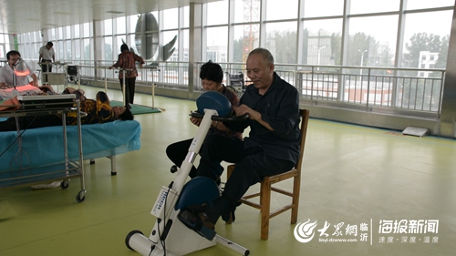 康复训练室内，老人在康复治疗师的陪同下做康复锻炼.jpg