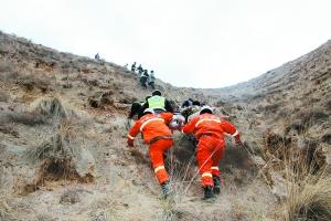 　　救援人员从深沟里将伤员抬上山。通讯员胡建华记者赵野摄