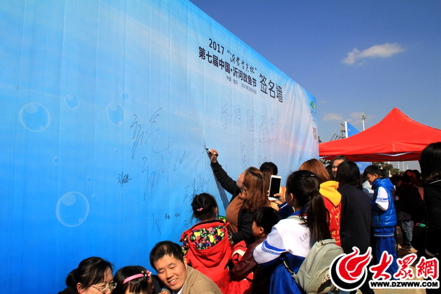 19、参与放鱼的市民在签名墙上签名.jpg