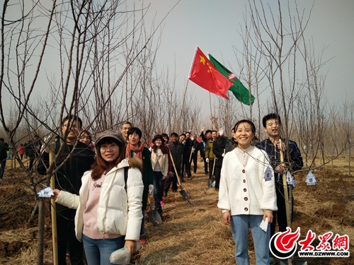 临沂新闻大厦员工与自己种植的海棠树合影留念。.jpg