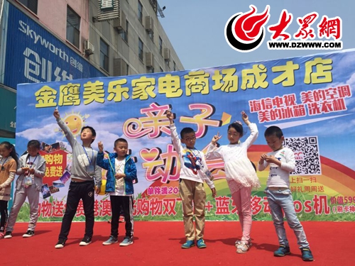 金鹰美乐家电商场成才路店的亲子运动会结束后，获奖小朋友手拿银条，在舞台上欢呼雀跃.jpg