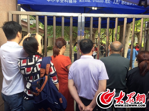 考生们开始入场，考场外，家长们在往里张望。.jpg