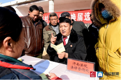 在沂南縣青駝鎮石門村選舉現場,孫慶禮向群眾宣傳《選舉法》的有關